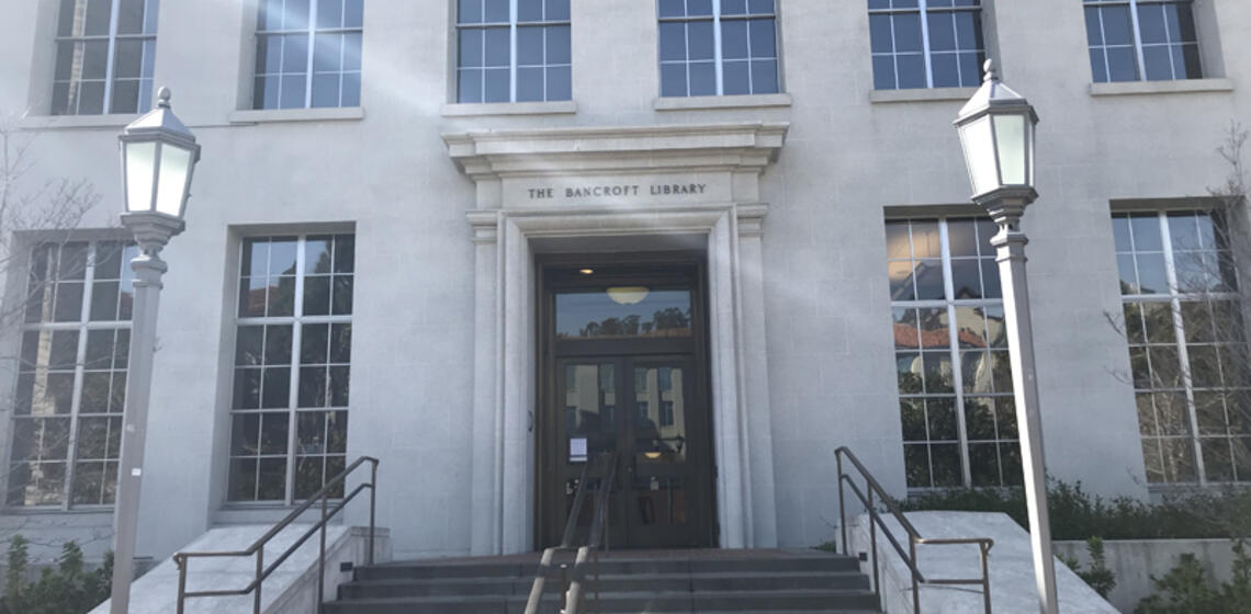 The front side of the Bancroft Library, facing east. In front of the main entrance is a small set of stairs.