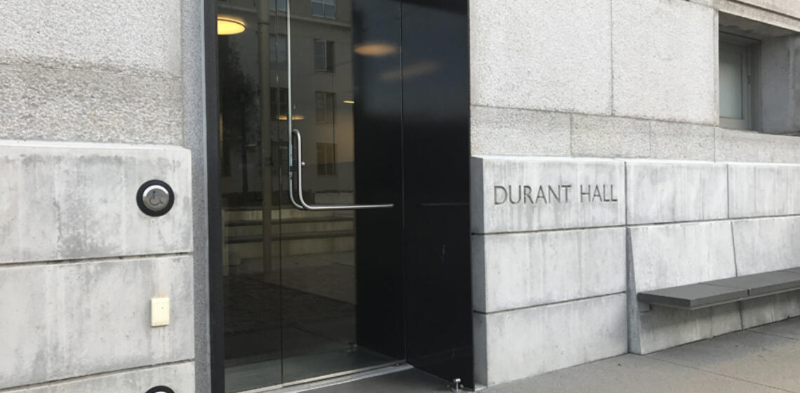 The west entrance to Durant Hall. To the left of the entrance is an automatic door opener.
