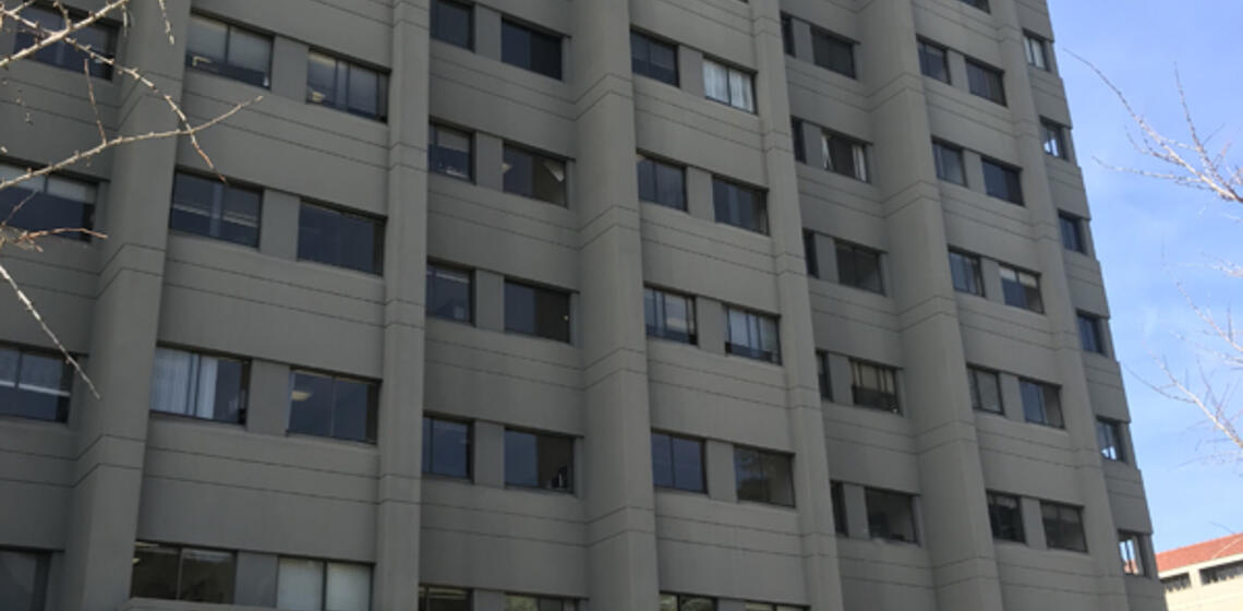 A southeast view of Evans Hall. There are access paths on either side of the main entrance.