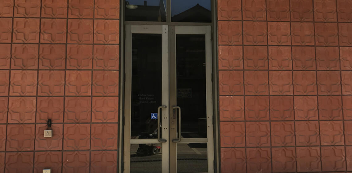 The upper entrance to Hildebrand Hall. To the left of the doors is an automatic door opener.