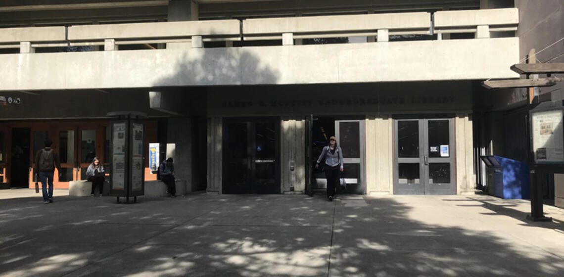 The lower south entrance to Moffitt Library. To the right of the leftmost set of doors is an automatic door opener.