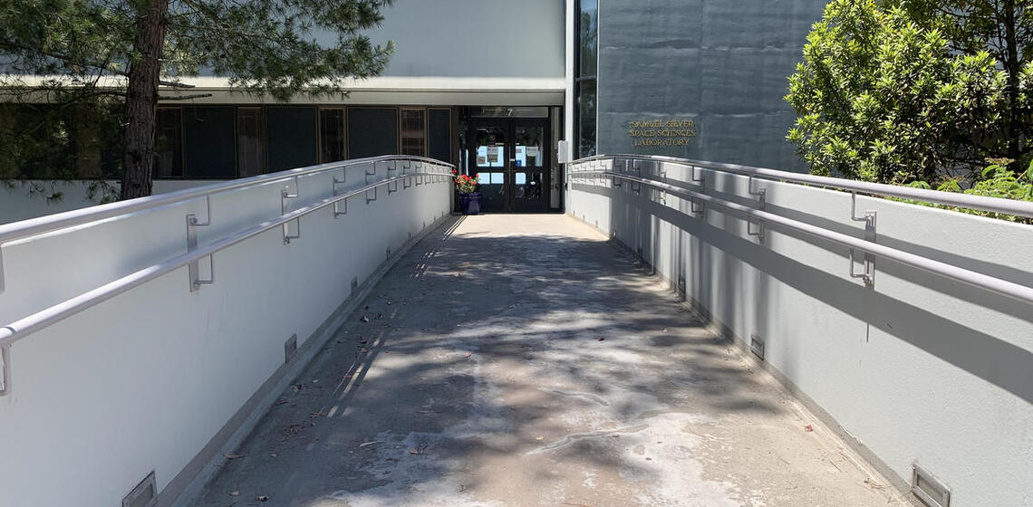 The main entrance to the Silver building, facing East. A bridge from the parking lot leads to the double doors.