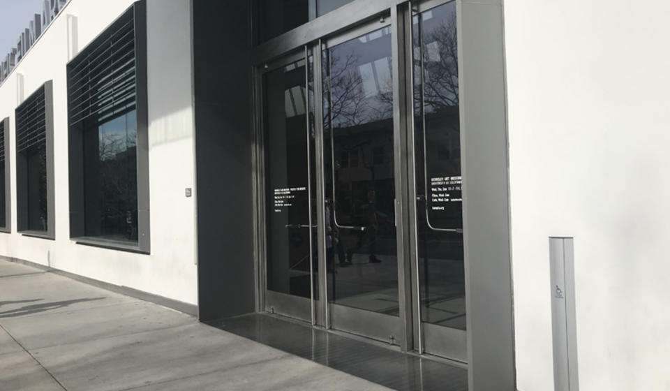 The southside entrance to BAMPFA. To the right of the entrance is an automatic door opener.
