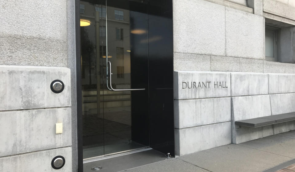 The west entrance to Durant Hall. To the left of the entrance is an automatic door opener.