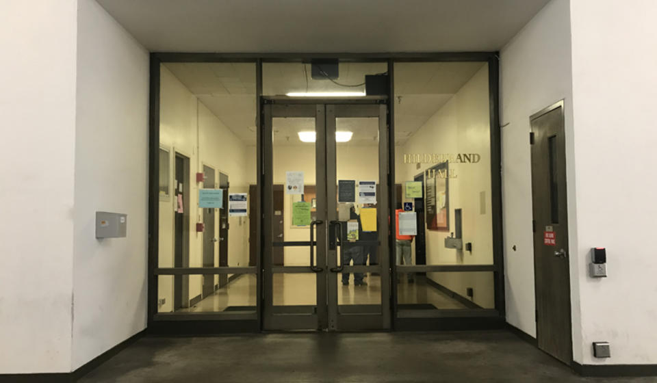 The lower entrance to Hildebrand Hall. To the right of the entrance is an automatic door opener.