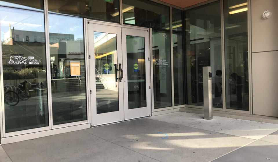An accessible entrance to MLK, facing south. To the right of the entrance is an automatic door opener.