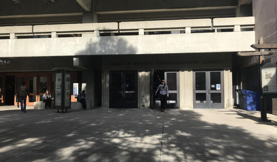 The lower south entrance to Moffitt Library. To the right of the leftmost set of doors is an automatic door opener.