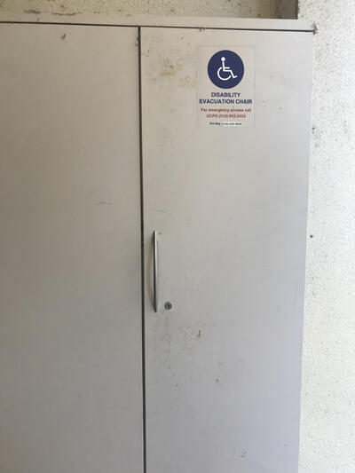 The evacuation chair for Moses Hall, located outside the east entrance. It is positioned in an evacuation cabinet. 