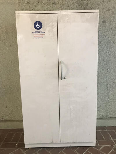 The evacuation chair for Stephens Hall, located outside of the north entrance. It is situated in an evacuation cabinet. 
